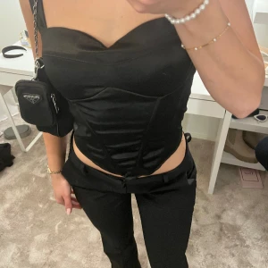 Fin topp från RagLady - Endast använd 1 gång, inbyggd bygel, korsett och resår i ryggen. Inga defekter, knytena går att justera! Satin! Storlek S/M