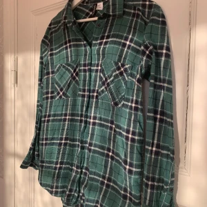 Grön flanellskjorta - Mörkgrön, vit och mörkblå rutig flanellskjorta från H&M i storlek 38. Har inga hål eller fläckar.