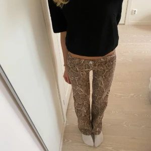 Lågmidjade ormskinnsmönstrade jeans - Så sjukt coola lågmidjade ormskinnsmönstrade jeans från h&m som är helt oanvända med lappen kvar💕 midjemått 38 rakt över, innerbenslängd 80 (jag är 175)