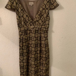 Karen Millen - Silk dress,  beige and black geometric pattern. Size Eu38/S (sizing is small, really a size Eu 36). New. Never worn. Lined. Buckle at waist. 