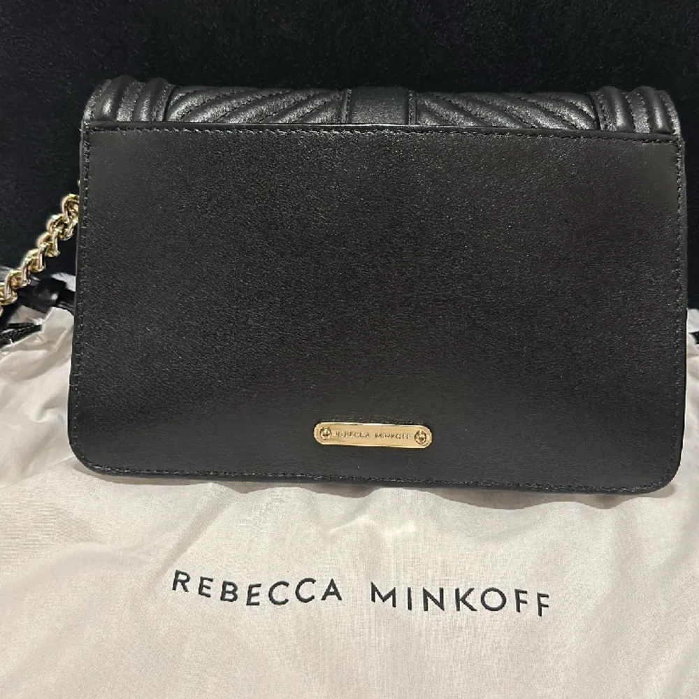 Rebecca Minkoff väska.  En mindre väska i fin kvalite med svart läderband med gulddetajer.  . Väskor.