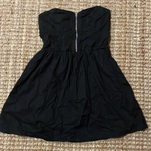 Klänning  - Resår i ryggen å dragkedja fram. 