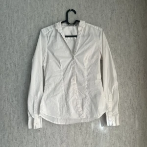 Vit skjorta - Vit figursydd skjorta i storlek 34. Använd fåtal gånger, säljer pga den ej passar perfekt längre och kommer ej till användning. Styker den innan den skickas
