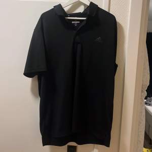 En svart adidas golftröja. Använd typ 3ggr