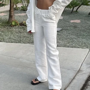 LÅGMIDJADE LINNEBYXOR - Vita linnebyxor från adsgn som en skräddare sytt till lågmidjat. Passar nån som är 160-163cm.