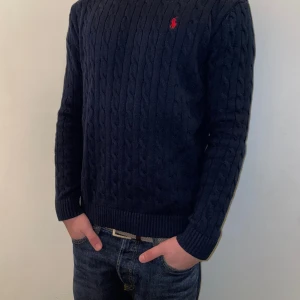 Tröja Polo Cable knitted  - Letar du efter en ny tjocktröja till vår-garderoben? Då är detta något för dig!   Marinblå tjocktröja från polo, Bra kvalitet och endast använd vid ett fåtal tillfällen. Priset kan diskuteras vid smidig affär. 