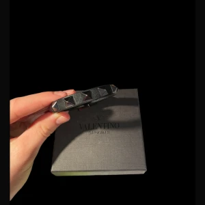 Valentino armband - Tja säljer nu mitt valentino armband i färgen svart, knappt använt. De är köpt på nk o allt ingår, lådan, dustbag, extra nitar osv. Hör av dig vid minsta fråga elr fundering!! 