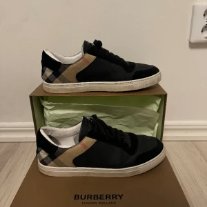 Burberry skor -  "Hej! Jag säljer ett par Burberry skor i storlek 45. De är lite sönder, men det syns inte när man har på sig dem. Perfekta för att ge din outfit en stilfull touch. Kvitto medföljer !