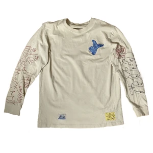 Weekday x Lee tröja med tryck - Crémefärgad WeekdayxLee tröja med tryck i bra skick, 100% bomull. Säljer då den är för liten på mig! Skriv om du vill ha bild på hur den ser ut på. 