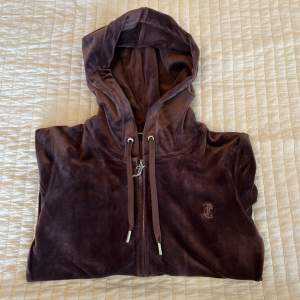 Säljer min bruna Juicy Couture hoodie då den inte längre kommer till användning.  (Bild 3. En söm sticker ut något, dock inget som syns vid användning).  Säljer även byxorna (storlek S). Hör av dig om du vill köpa båda två!    Ordinarie pris: 1300kr 