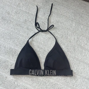 Calvin Klein bikini topp  - Överdel från Calvin Klein Swimwear. Superfin! Den är vadderad men dessa kan tas ut om man föredrar utan.  Nypris 599: https://www.calvinklein.se/triangle-bikini-top-intense-power-kw0kw01824beh?cmpid=ch:cpc&&pdg=:cmp-18021097405:adg-:crv-:pos-&gad_sou