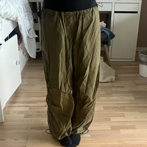 Parachute pants - Parachute pants från pull and bear!! 💚 säljer pga jag inte använder längre. Byxorna är skrynkliga då jag inte har strykt dem, men annars inga andra stora defekter!! Fickor på sidan och där bak! Justerbara i midjan och vid anklarna💚🤎 strl M