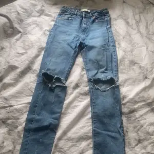 Blåa skinny jeans med fabriksgjorda hål på knäna och liten slitningar ifrån Ginatricot i strl M. Ganska tajta i modellen så skulle säga att de är mera som S. Knappt använda och säljer då dem inte passar längre