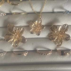 Guldiga halsband med blomma, endast berlock säljs, går att sätta på vilket halsband som helst!🤩(örhängen säljs i annan annons)💋😍 örhängen+halsband i paket säljs för 200🥰 Pris kan diskuteras vid snabb affär💞