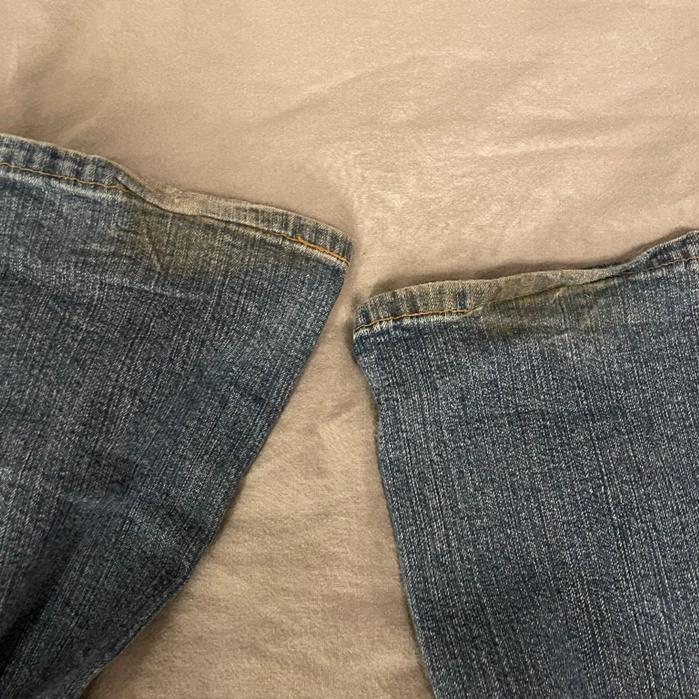 Ett par lågmidjade bootcut jeans köpta här på plick. Jeansen är i gott skick förutom slitningar längst ned på benen. Midjemått: 80 cm Innerbenslängd: 85 cm. Jeans & Byxor.