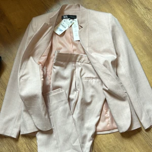 Kostym Zara - Oanvänd kostym Zara Taggen kvar kavajen ej byxorna Ljusrosa, bilderna  missvisande färg, är mer rosa, men inte ”babyrosa”. Köparen betalar frakt  Vid gylfen finns ett litet sträck i oranget, ca 1/2 cm. Syns knappt men för kännedom. Rökfri har hund 