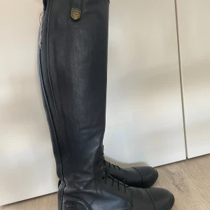 Mountain Horse - Supreme High Rider - Stl 39 Long/Narrow - Säljer dessa fina ridstövlar från Mountain Horse i stl 39 - Long/Narrow. De är fortfarande i jättefint skick och det enda slitagen som finns är några gamla fettfläckar från skofett på insidan av stövlarna.  De är 51 cm i höjd och ca 32-34 cm i vaden.