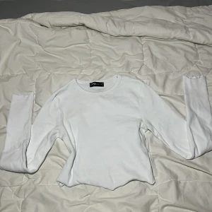 Vit långärmad croptop - Köpt på NewYorker nästan 2 år sedan. Använd ungefär 5 gånger. Bra skick. Magtröja som börjar ovanför naveln.