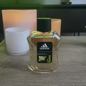 Adidas Pure Game öppnar med en spännande blandning av grapefrukt och mandarin, som framhävs av grön basilika och kryddigt frisk peppar. I doftens hjärta finns aromatisk lavendel, guaiac-trä och cypress som ger doften sin maskulina, eleganta touch.