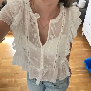 Vit blus  - Säljer denna sjukt fina vita blusen med volanger och broderier🤩perfekt nu till sommaren💓tveka inte om ni har några frågor!!