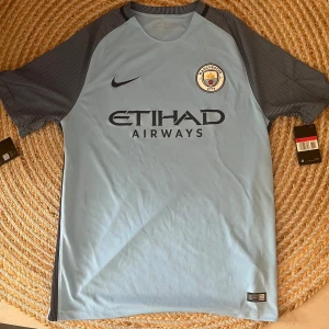 Manchester City tröja - Säljer nu min Manchester City tröja jag köpte i Manchester 2019 i samband med match. Har alltid varit för stor, trodde jag skulle växa in i den, därav är prislappen kvar.