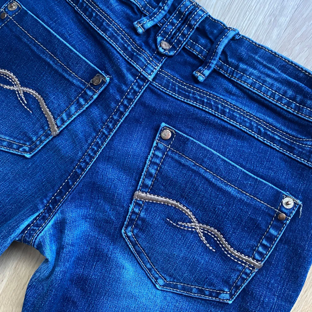 Lågmidjade bootcut jeans i en mörkblå färg. Snygga bakfickor med mönster. Passar xs-s. Jeans & Byxor.