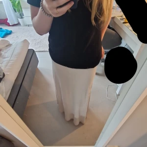 Beige långkjol  - En fin beige långkjol från H&M som inte kommit till använding. Lapparna är bortklippta (se bild) jag kan klippa bort lite till om man skulle vilja. Resåren i midjan är rätt så tajt så den är mer st S/XS än M. Satt pris gäller.💕