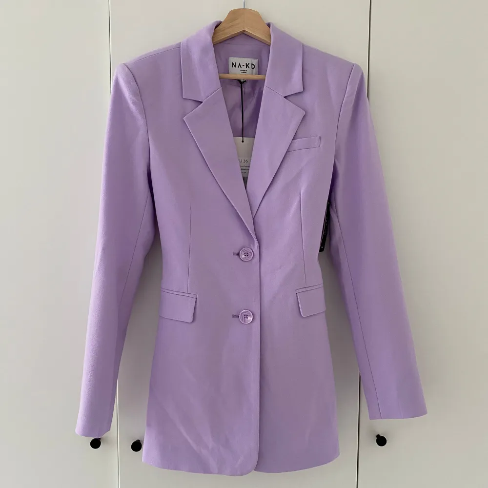 Säljer denna fina kavaj/blazer från nakd i en fin pastell lila färg. Den är helt oanvänd med lappen kvar och är i storlek 36. Fin detalj på ryggen med stören som går att knyta och spänna åt så som man önskar. Köparen står för frakt💕. Kostymer.