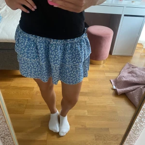 Blåblommig kjol - Här är en blå kjol med blommor på. Jättefin nu till sommaren. Den här är köpt på shein för några år sedan och knappt använd. Storlek S. Pris kan diskuteras