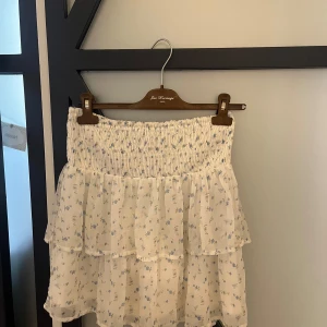 Volangkjol - Jätte gullig volangkjol från Vero Moda med små blåa blommor! Den har används fåtal gånger och kommer inte till användning. Inga defekter. Passar S-M