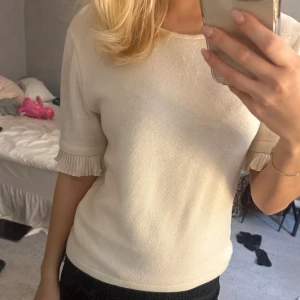 Zara t-shirt - Vitbeige zara t-shirt med volanger i ärmarna Lite nopprig men går att ta bort enkelt Den är storl L men passar mig som har s i toppar
