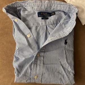 Ralph lauren skjorta  - Riktigt fet Ralph lauren skjorta som nu ska säljas för den är för liten. Storlek 14 som motsvarar ungefär 155-160. Köpte på nk barn tyvärr inget kvitto kvar. Men där emot är det i väldigt bra skick använd ett fåtal gånger. Frågor bara skriv👍🏽
