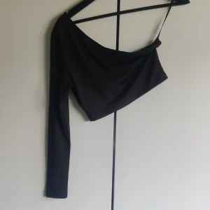 Topp - Topp som är off-shoulder på ena sidan. Kan bäras åt båda håll. Har ingen lapp i men skulle gissa att det är en xs/s.