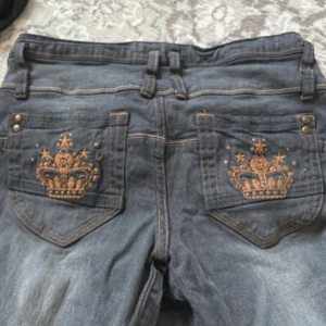 Jeans med kronor - Jätte snygga grå-blåa jeans som är i bra skick. Köpt secondhand men har aldrig använts av mig. Står att det är för 13 år men passar XS bra🥰 