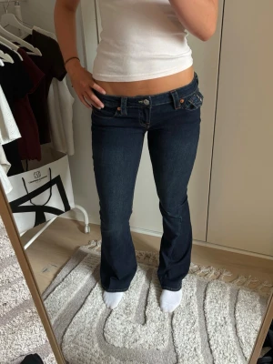 Mörkblå bootcut jeans True Religion - Säljer ett par oanvända mörkblå bootcut jeans från True Religion med låg midja i modellen joey, säljer pga att de aldrig kommit till användning💕
