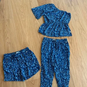 Blått set från Mq med One shoulder topp  - Snyggt set från MQ med One shoulder topp i en härlig blå ton! Säljer det i paket med byxa, shorts och topp. Använt ett fåtal gånger, mkt bra skick! Rökfritt hem!
