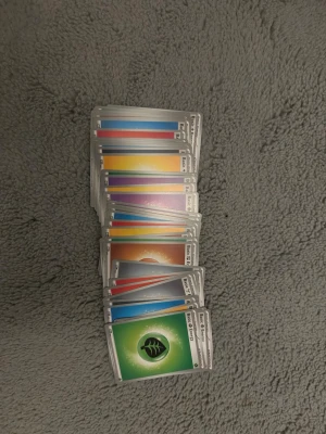 Pokémon energikort bunt - En bunt Pokémon energikort i olika färger och element, perfekta för att bygga eller komplettera din samling. Korten har klassisk Pokémon-design med färgglada framsidor och den ikoniska baksidan. Materialet är glansigt papper.