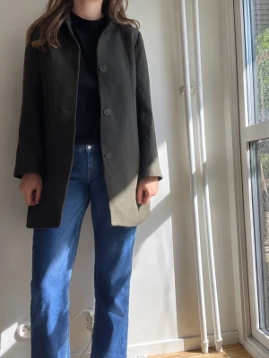 COS Mörkgrön ullkappa - 90 % ullkappa från COS i storlek M. I perfekt skick utan några tecken på slitage. Normal i storleken.