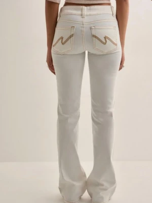 Nelly jeans - Snygga vita bootcut jeans med hög midja och kontrastsömmar från Nelly. Köptes för ett år sedan och är använda fåtal gånger. Har tvättat dem nu så tycker de är lite sträva och inget jag längre använder.🤍