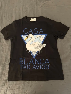 Casablanca t-shirt -  svart t-shirt med tryck av en vit svan i en blå triangel och texten 'Casa Blanca Par Avion' på framsidan. Kom dm vid frågor!!