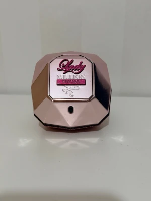 Lady Million Empire parfym limited edition 80ml - Säljer en Lady Million Empire parfym från Paco Rabanne. Flaskan har en unik diamantform i metallic rosa och glittrig finish, med detaljer i rosa och silver. En lyxig och elegant doftflaska som verkligen sticker ut på hyllan.