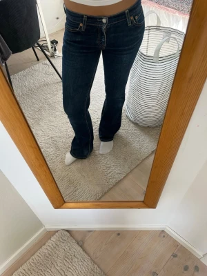 Mörkblå bootcut Levis jeans - Säljer ett par mörkblå bootcut jeans från Levis. Lågmidjade och bra skick. Storlek 27/32.