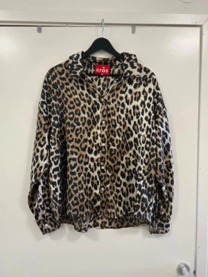 Leopardmönstrad skjorta från Crās - Snygg skjorta från Crās med leopardmönster i bruna, svarta och beige toner. Skjortan har klassisk krage, knäppning framtill och långa ärmar med manschett. Perfekt för dig som vill sticka ut med en trendig look.