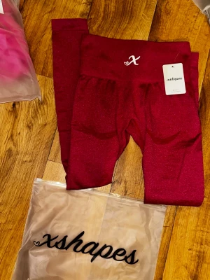 leggings xshapes - Snygga rosa leggings från xshapes med hög midja och stretchigt material. Perfekta för träning eller chill, med diskret logga.. Kommer i originalpåse och med tag kvar.