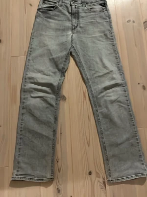 Grå Replay Jeans - Snygga grå replays med rak passform och hög midja. Klassisk femficksmodell med detaljerade sömmar på bakfickorna. Jeansen har en tvättad look och är tillverkade i denim, perfekt för en avslappnad stil. Storleken är 12A eller och passar perfekt till 150 cm längd. 