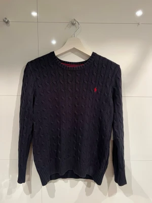 Ralph Lauren cable knit sweatshirt - Hej, säljer en navy blå Ralph Lauren cable knit sweatshirt i storlek L (14-16) men passar även XS. Skick 9/10 använd fåtal gånger. Har inga defekter eller är ej solblekt. Modellen på bilden är 172cm lång.  Vid fler frågor eller funderingar tveka inte att höra av dig. Priset kan diskuteras vid snabb affär!