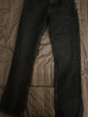 Svarta raka jeans - Ett par svarta jeans med rak passform och klassisk femficksdesign. Jeansen har normal midja och är tillverkade i denim. Perfekta för dig som gillar en enkel och stilren look.