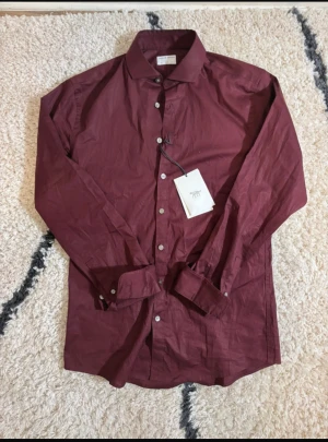 Tiger of Sweden skjorta  - Snygg vinröd skjorta från Tiger of Sweden i slim fit-modell. Lappen är inte kvar men Skjortan är i nyskick, pris kan diskuteras skriv om ni undrar över något! 