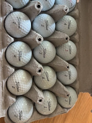 Titleist prov1 i kartong - Säljer ett gäng vita golfbollar från Titleist, snyggt förvarade i en äggkartong. Perfekt för dig som vill fylla på golfväskan med kvalitetsbollar. Numreringen på bollarna varierar mellan 1 och 4.