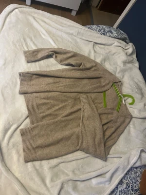 Beige stickad kofta - de va en stickad tröja som jag klippt i mitten men den är fin och skön på! passar s-m